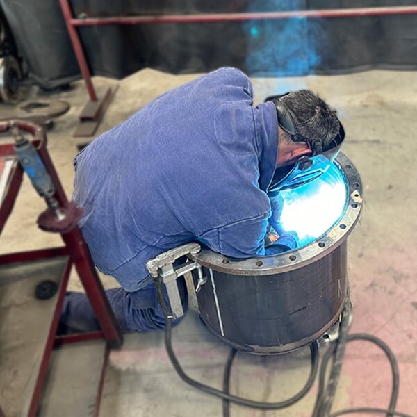 Schweißer führt präzise Innennahtarbeiten an einem zylindrischen Metallbauteil aus während einer Hatec Industriemontage mit Fokus auf hochwertige Fertigung und Instandhaltung