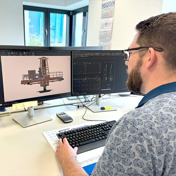 Ingenieur arbeitet am CAD Modell einer Industrieanlage am Doppelmonitor in der Konstruktionsabteilung der Hatec Group mit Fokus auf technische Planung und Anlagenentwicklung