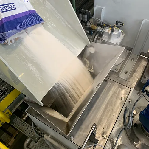 Bef&uuml;llung einer industriellen Sonderanlage mit pulverf&ouml;rmigem Material in einem Edelstahltrichter von Storm Anlagenbau