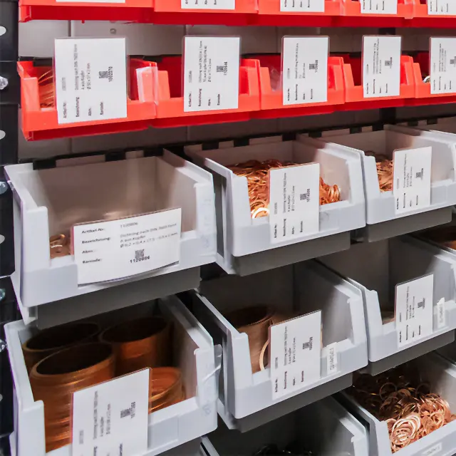 Regalfächer mit sortierten Dichtungsringen aus Metall in beschrifteten Lagerboxen und übersichtlicher Materialorganisation im Industriebedarf